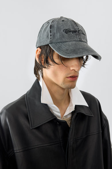 Model wearing Carpe Diem baseball cap in grey made out of recycled cotton, featuring an grey embroidery and a silver-tone buckle in the back