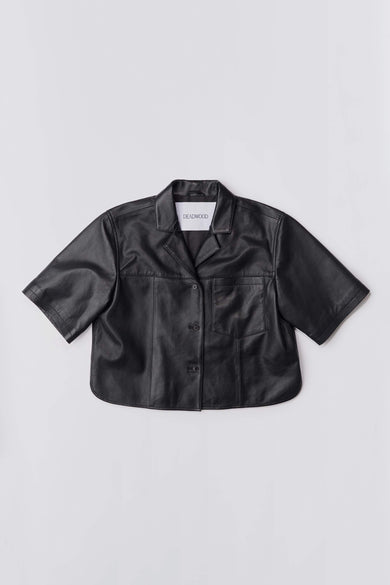 Black Deadwood cropped short-sleeve leather shirt with camp collar and button closure. Crafted from upcycled lambskin leather.